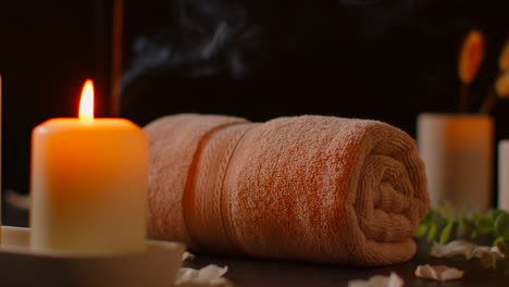 Still-Life-Of-Lit-Candles-With-Scattered-Petals-Incense-Stick-And-Soft-Towels-Against-Dark-Background-As-Part-Of-Relaxing-Spa-Day-Decor-3